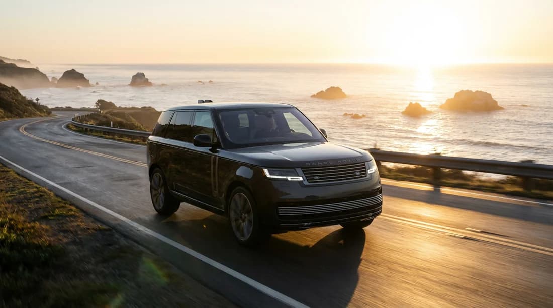 Une voiture de luxe roulant sur une route côtière au lever du soleil symbolisant la sérénité et le bon entretien