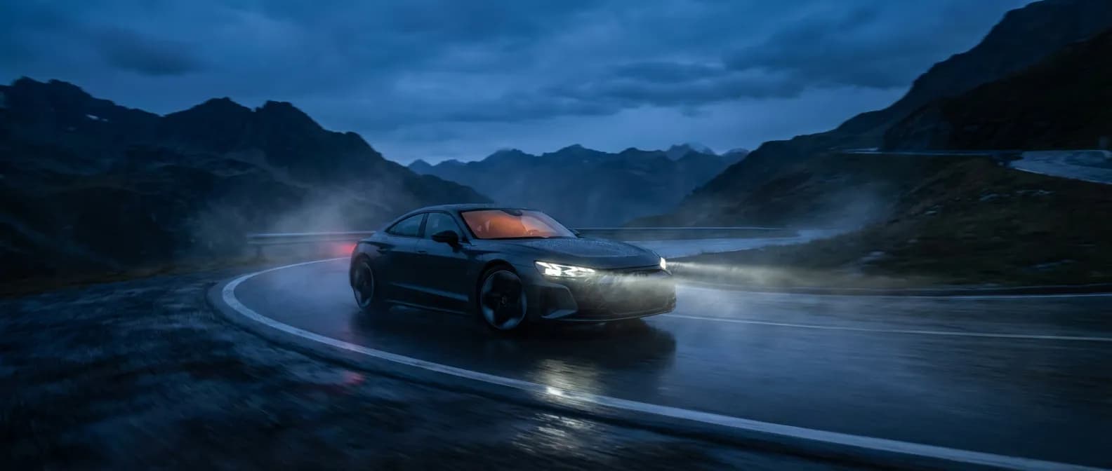 Voiture circulant sur une route sinueuse sous la pluie avec le voyant orange zigzag activé